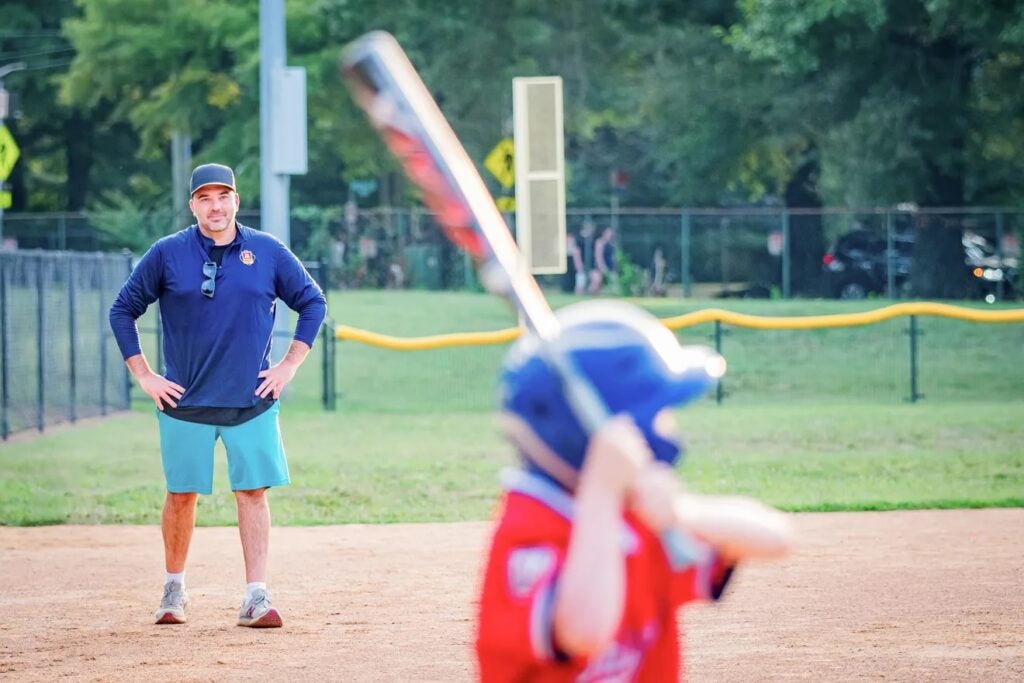 Coach Mike coaching a kid getting ready to bat.